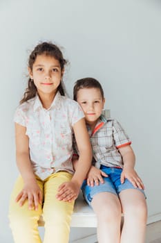 boy sitting next to girl on white background