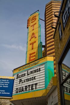 Vibrant vintage theater marquee on State Street in Ann Arbor, Michigan. Neon letters illuminate the titles 'Silver Linings Playbook' and 'Quartet.' Nostalgic charm meets the excitement of cinema.