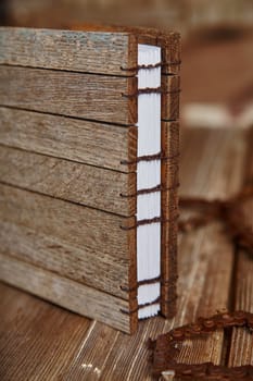 Handcrafted wooden notebook with coptic stitch binding showcasing intricate craftsmanship. Vintage charm and artisanal appeal for creative writing and journaling. Fort Wayne, Indiana.