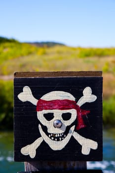 Jolly Roger pirate flag with rustic charm against a sunny outdoor backdrop. Adventure, piracy, and nautical folklore come to life in Empire, Michigan.