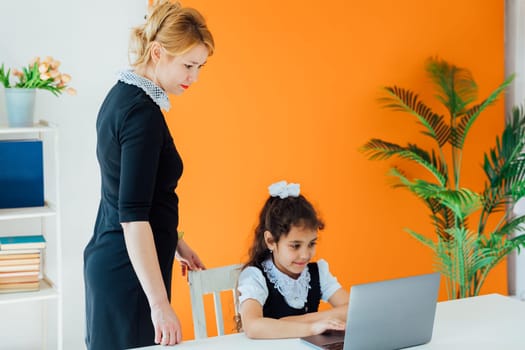 teacher in lesson at school teaching children on laptop