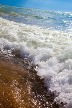 Experience the raw power and tranquil beauty of Lake Michigan's crashing waves on a sunny day at the beach - a perfect summer getaway.
