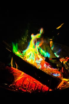 Vibrant campfire illuminates the night, casting an enchanting glow. Experience the warmth and beauty of nature's colorful flames in Fort Wayne, Indiana.