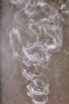 Mesmerizing dance of ethereal smoke swirls against neutral backdrop, capturing transient beauty and mystery. Perfect for meditation, health, and wellness concepts.