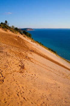 Explore the stunning sandy slopes and pristine blue waters of Michigan's Empire State Park, capturing the essence of adventure and natural beauty.