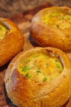 Indulge in the ultimate comfort food with these golden-brown bread bowls, filled to the brim with a delicious quiche filling and topped with vibrant herbs. Perfect for cozy nights in and gourmet dining experiences. Fort Wayne, Indiana.