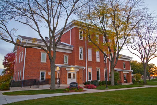 Twilight tranquility at Winfield Symphysis Center, a majestic red brick building nestled in Fort Wayne, Indiana. The classic architecture and serene surroundings evoke a sense of tradition and calm, perfect for educational themes.