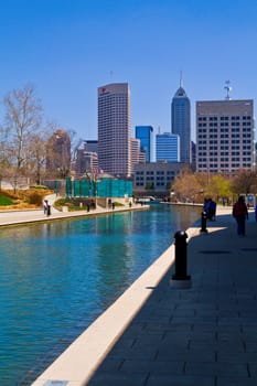 Vibrant cityscape of Indianapolis downtown, showcasing a harmonious blend of urban architecture and natural elements along a tranquil canal.