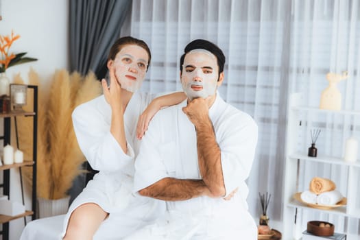 Serene modern daylight ambiance of spa salon, couple customer indulges in rejuvenating with facial skincare mask. Facial skin treatment and beauty cosmetology procedure for face. Quiescent