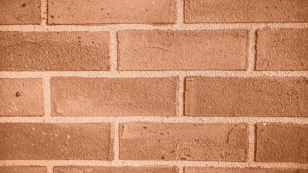 The background of the brick wall. Image toned in Peach Fuzz color of the year 2024. Antique weathered wall Grunge background The backdrop, interior design