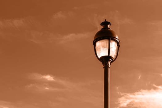 Public street lighting pole with LED lights with an amazing sunset color background. Image toned in Peach Fuzz color of the year 2024