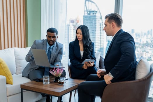 African businessman present start up project to expert investor. Group of multicultural business team solving problems, discussing business idea with skyscraper at modern business lounge. Ornamented