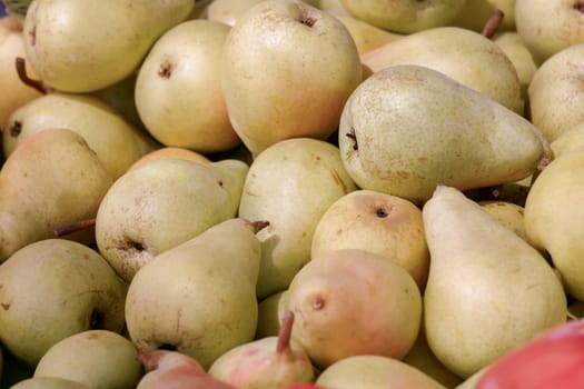 close-up of a pile of pears on a table in a street market