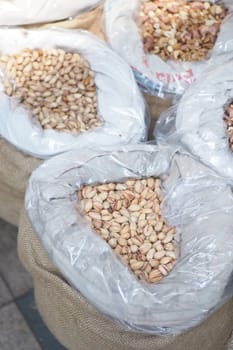 pistachios nuts in a big bag selling at shop .