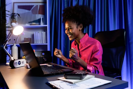 Working African woman with happy glowing, smiling face, getting new job project with good deal or marketing course scholarship information on laptop screen. Concept of cheerful expression. Tastemaker.