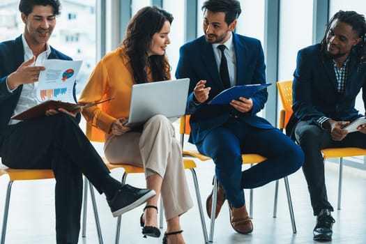 Diversity managers sitting while discussing their business plan. A businesswoman shares data on her laptop computer with an analyst during talking with her coworkers confident. Intellectual.