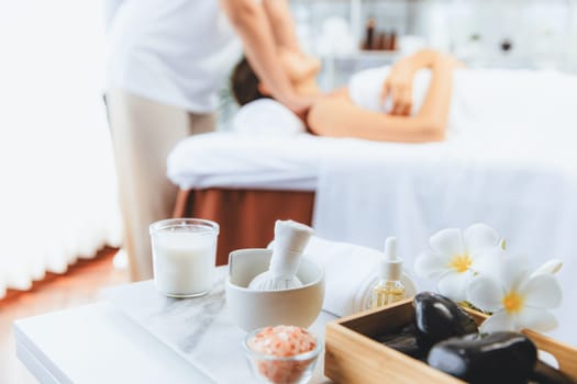 Aromatherapy massage on daylight ambiance or spa salon composition setup with focus decor and spa accessories on blur woman enjoying blissful aroma spa massage in resort or hotel background. Quiescent