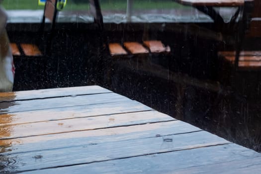 Raindrops falling on the surface of a street table close up