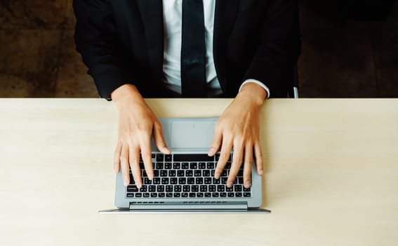 Business person or office worker using laptop computer while sitting at desk. uds