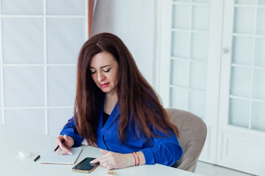 brunette woman negotiating on smartphone business online in office