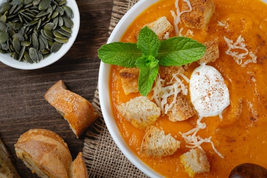 Creamy pumpkin soup garnished with croutons.