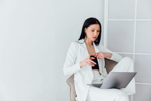 woman in white suit working on laptop small business online
