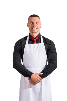 Attractive chef or waiter posing, wearing white apron and black shirt isolated on white background, in studio shot