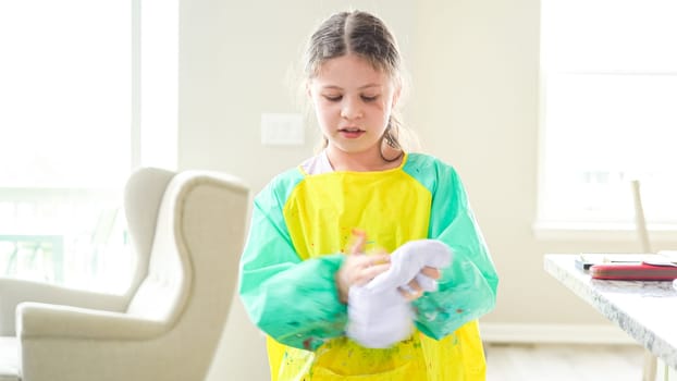 In a modern kitchen, a homeschooled girl is engrossed in creating homemade slime, a fun and educational hands-on project that enhances her creativity and problem-solving skills.