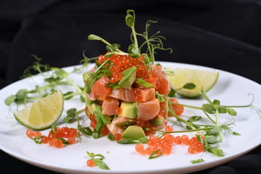 Avocado tartare with salmon, red caviar and pea sprouts.