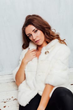 portrait of a beautiful woman with curls in a fur coat