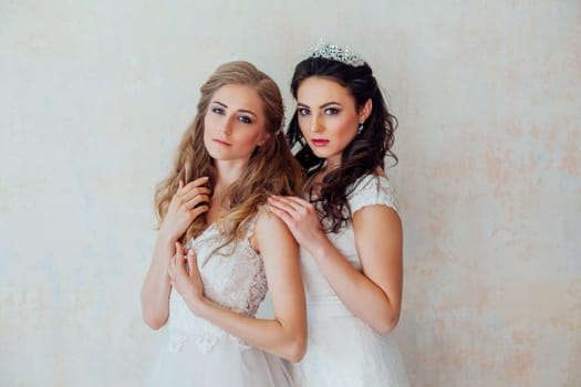 two girls in white dresses brunette and blonde 1