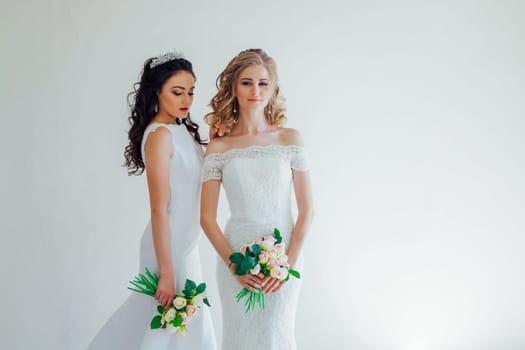 two wedding bride with a bouquet of flowers wedding hair blonde and brunette