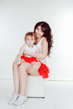 mother and little daughter in red skirts on a white background