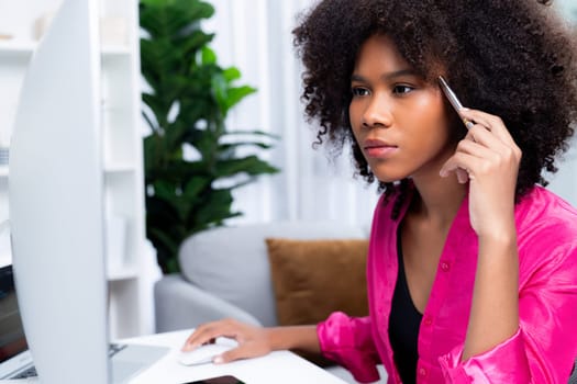 Working African woman blogger concentrated on the laptop screen with serious face, searching marketing data analysis, conclusion overall document on database for meeting report. Tastemaker.