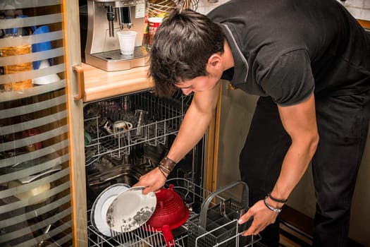 A man looking at a dishwasher