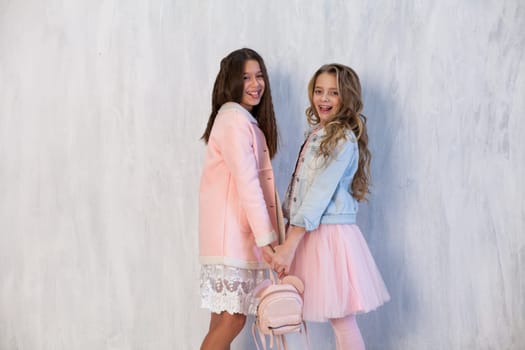 Portrait of two beautiful girl girlfriends in white pink clothes