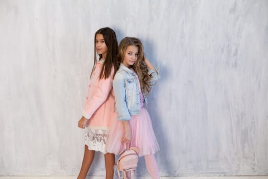 Portrait of two beautiful girl girlfriends in white pink clothes