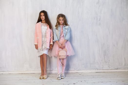 Portrait of two beautiful girl girlfriends in white pink clothes