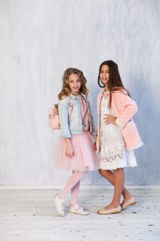 Portrait of two beautiful girl girlfriends in white pink clothes