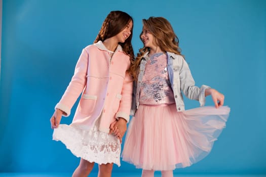 Portrait of two beautiful girl girlfriends in white pink clothes