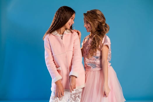 Portrait of two beautiful girl girlfriends in white pink clothes