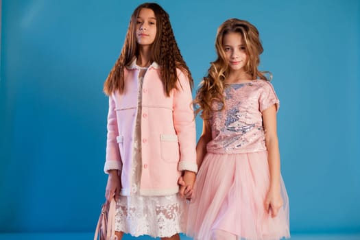 Portrait of two beautiful girl girlfriends in white pink clothes