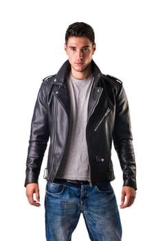 Young handsome man standing in studio shot, wearing black leather jacket and jeans