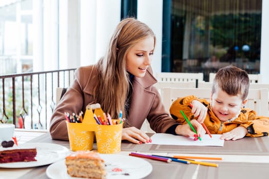 mother and son in the restaurant painted pencils before eating