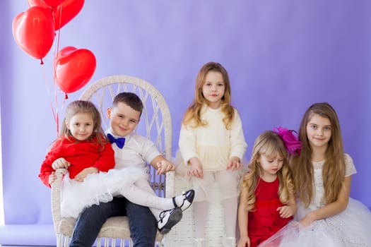 Boy and girls with red balloons on holiday