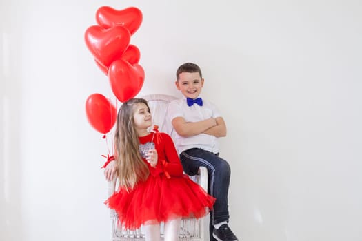 Boy and girl friends with red balloons on Valentine's Day