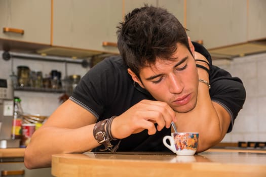 A man leaning over a table with a coffee cup