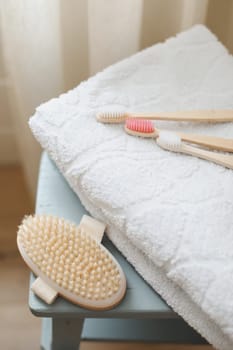 Set of body massage brush and bamboo toothbrushes with white towel. body care products natural materials, zero waste, spa body care concept. Eco-friendly lifestyle.