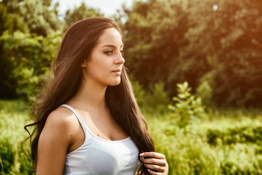 A woman with long hair standing in a field