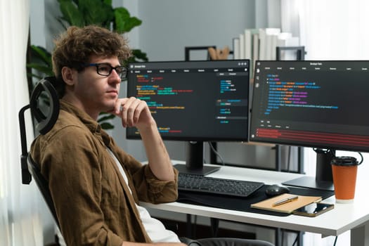 IT developer working online software development on pc monitors at modern home office on coding application screens, creating updated latest program firmware information version concept. Gusher.